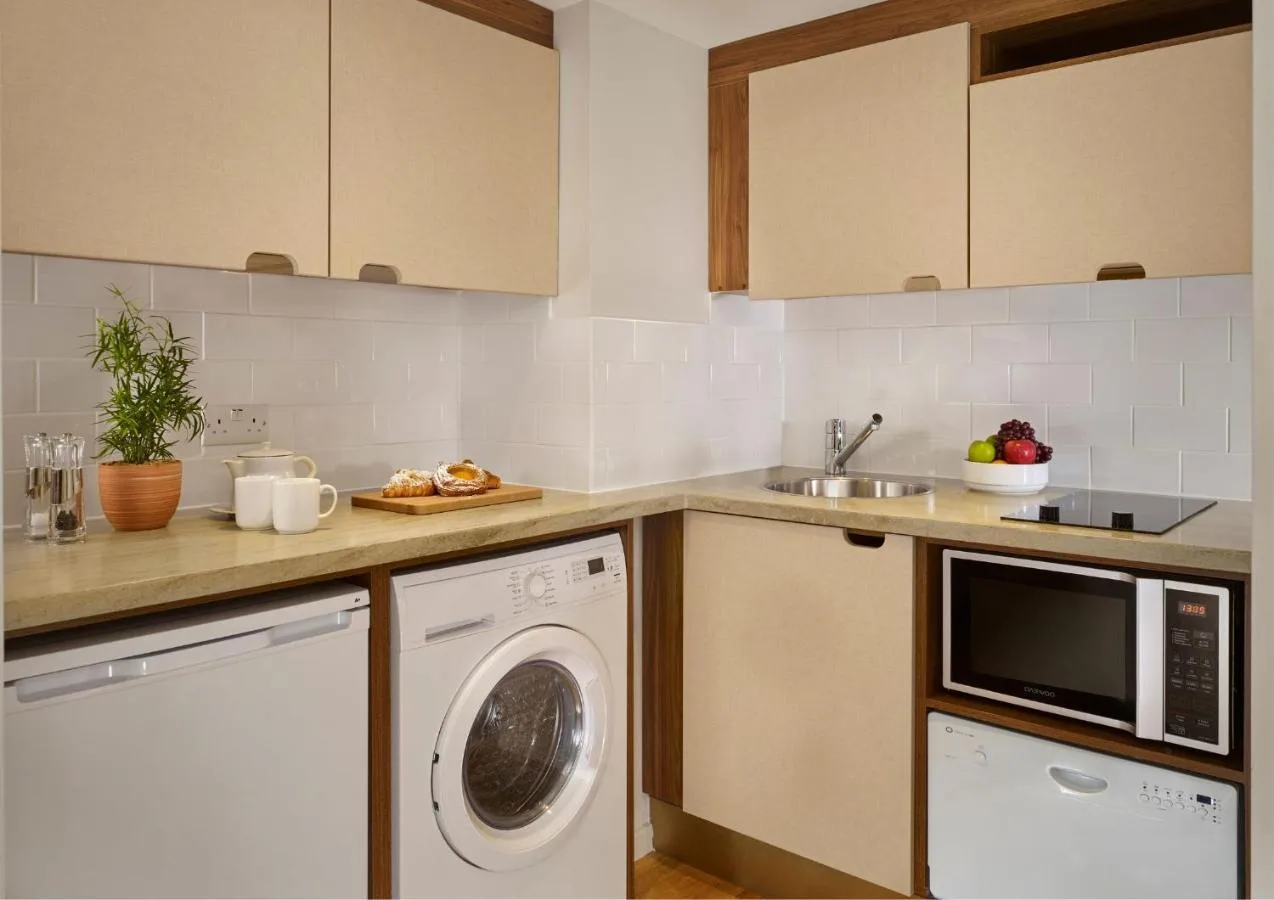 a kitchen with a washing machine and a dishwasher at Citadines Barbican London in London