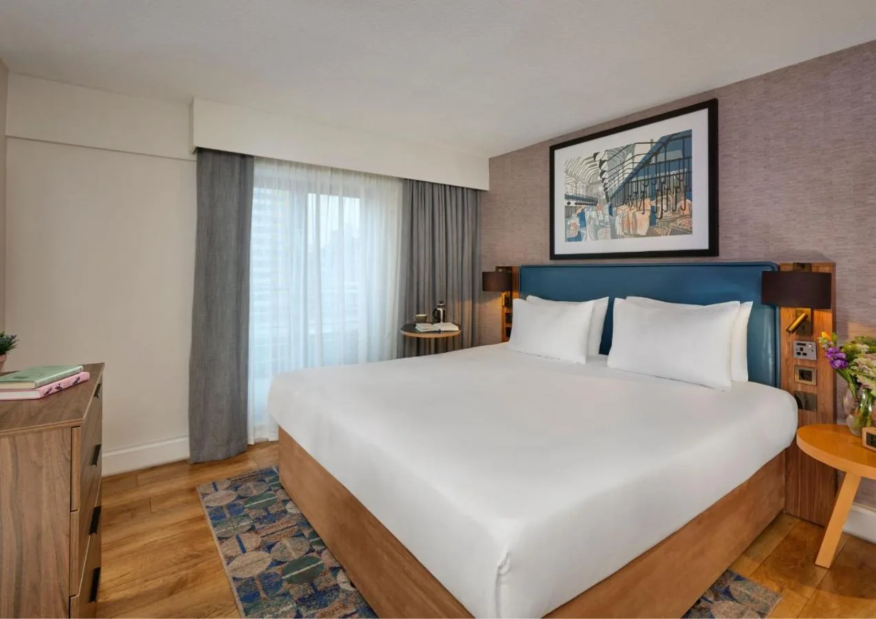 a bedroom with a large white bed and a window at Citadines Barbican London in London